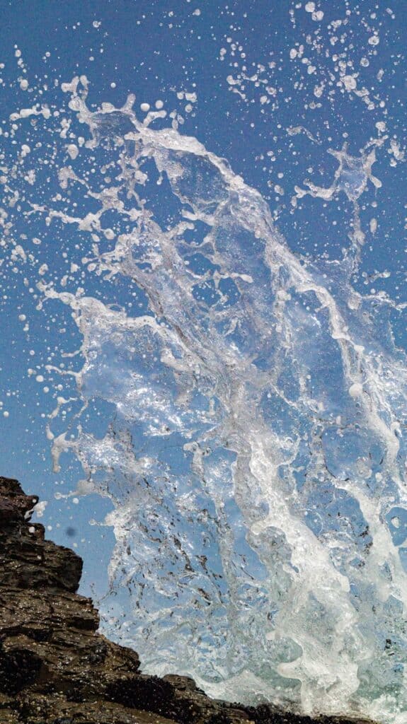 a person standing on top of a cliff under a blue sky