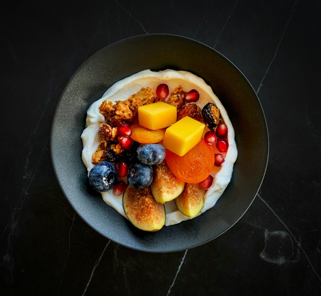 a bowl filled with fruit and nuts on top of a table