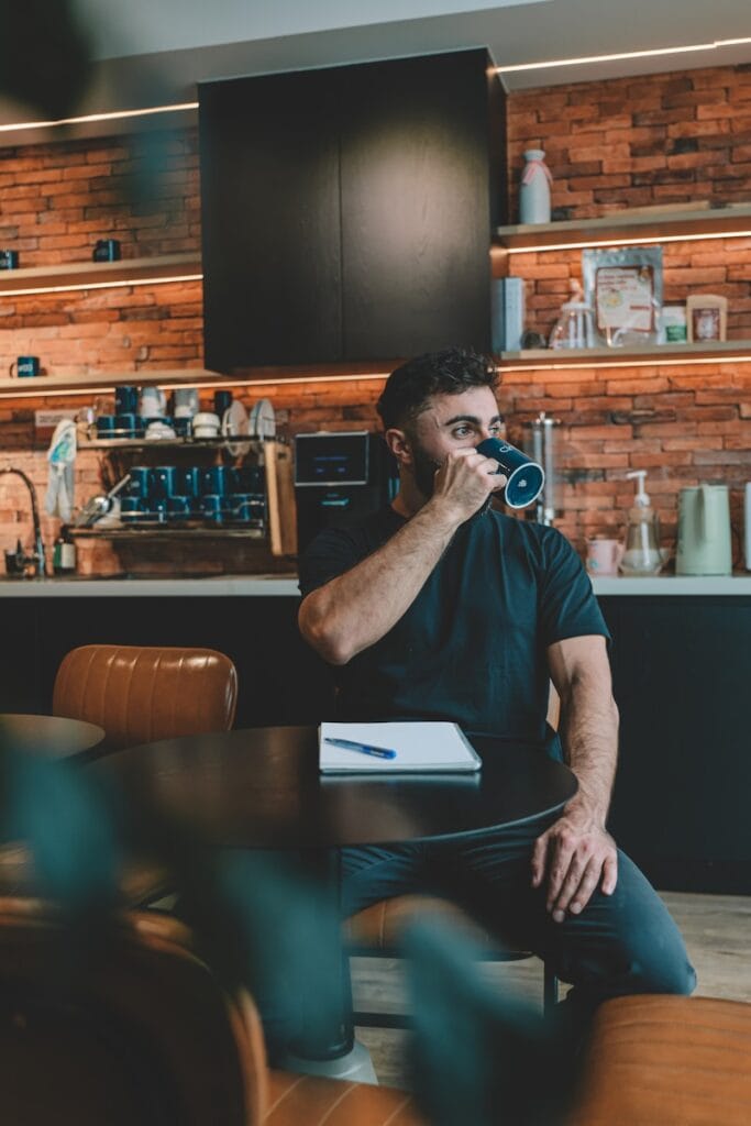 Man drinking coffee in a modern kitchen.