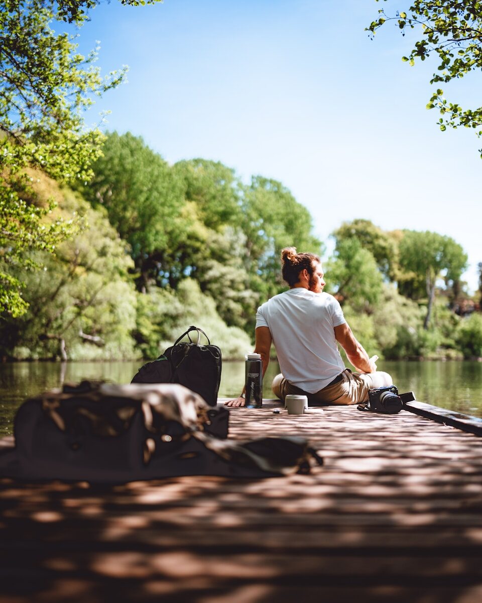 a man sitting on a bench under tender sun