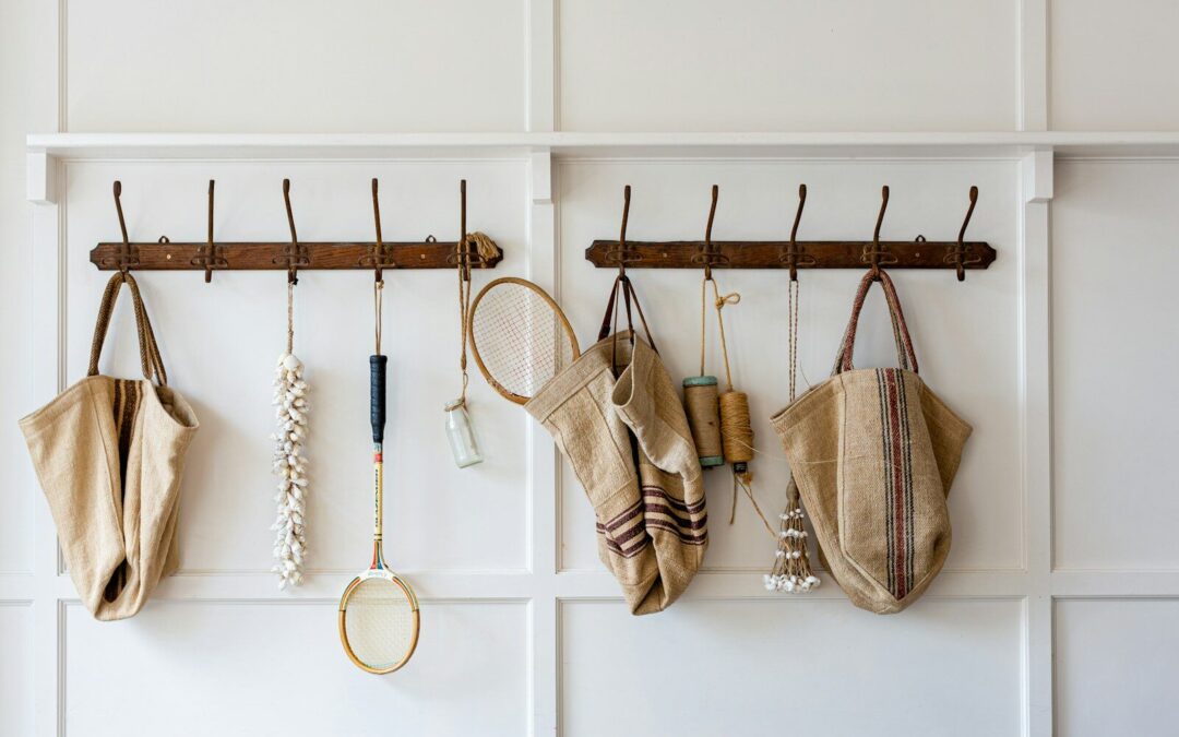 brown and white sling bags hanged on white wooden wall